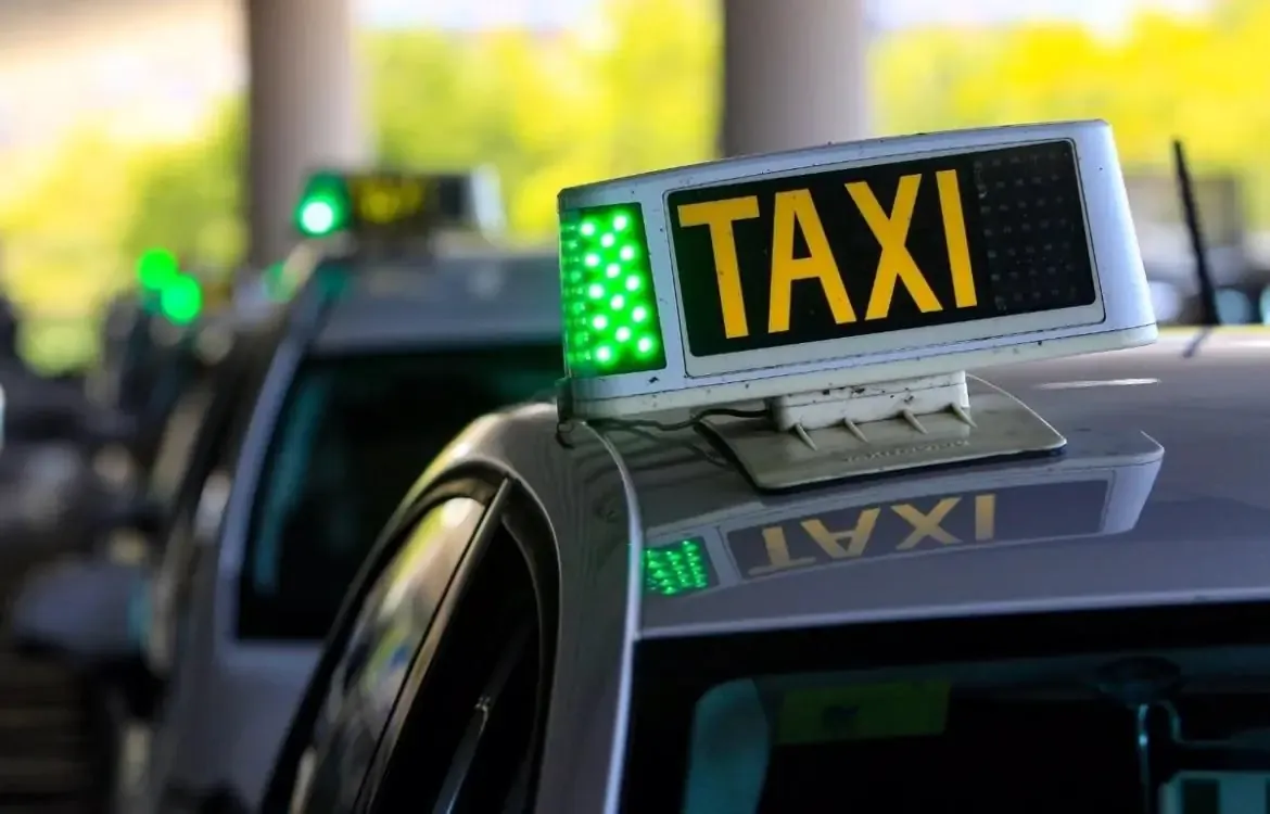 Letrero de taxi con la luz verde de libre encendida